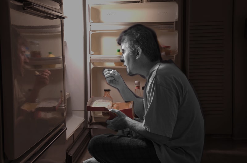 Man sitting in front of the refrigerator, in the dark, binging on ice cream.